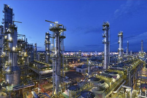 Refinaria iluminada ao anoitecer